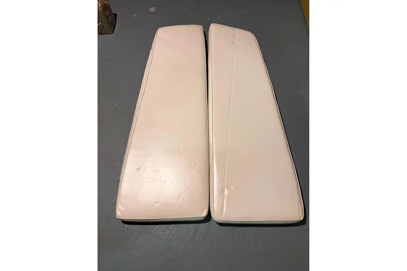 Slide: The Image of Two white boat cushions from a 1976 PAC 23 model, placed on a gray floor. - 6