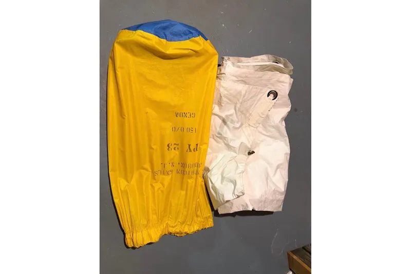Slide: The Image of Yellow and white PAC 23 sail from 1976, laid on a gray surface. - 8