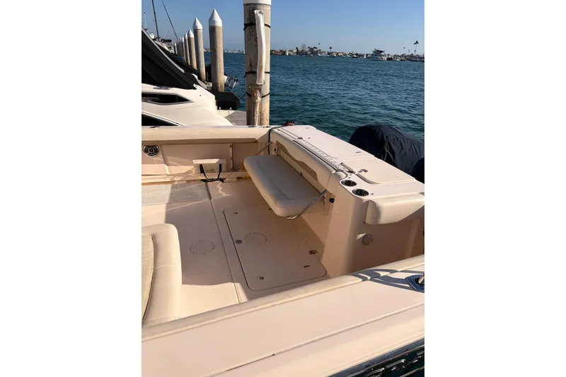 Slide: The Image of 2014 Grady-White Freedom 335 boat interior, docked by the water, showcasing seating and deck area. - 13