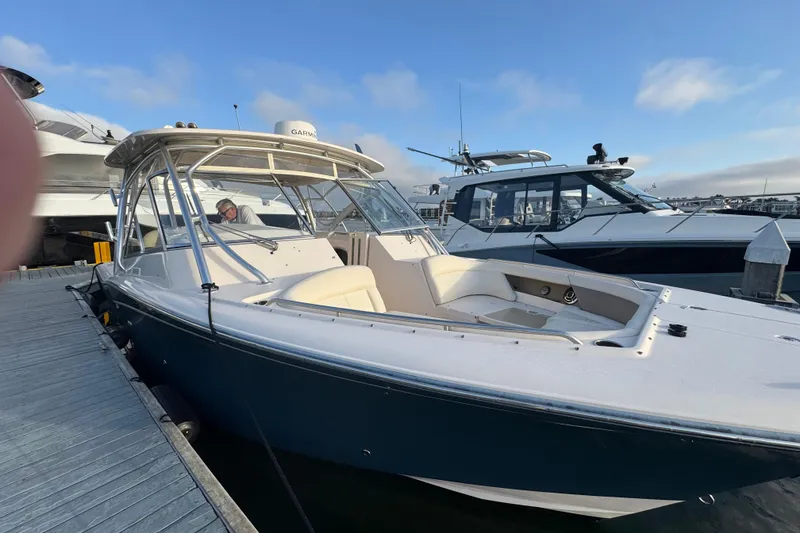 Slide: The Image of 2014 Grady-White Freedom 335 boat docked at marina under clear sky. - 16
