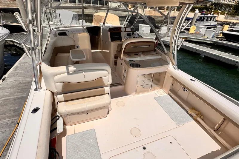Slide: The Image of 2014 Grady-White Freedom 335 boat interior at dock, featuring seating and helm station. - 18