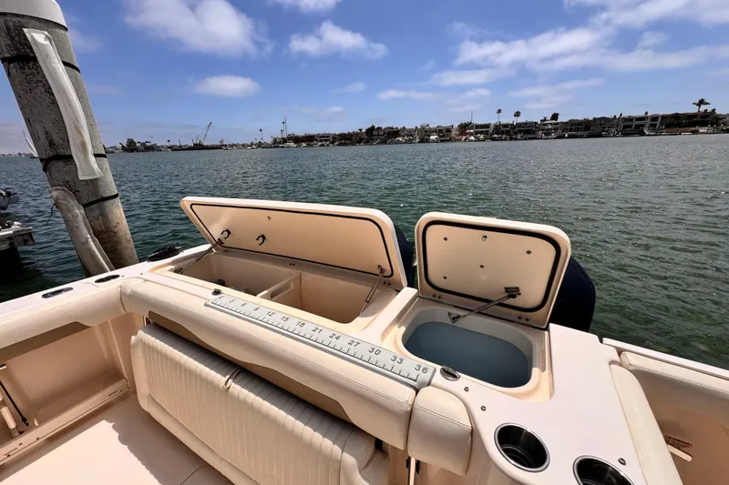 Slide: The Image of 2014 Grady-White Freedom 335 boat with open storage compartments on a sunny day. - 20