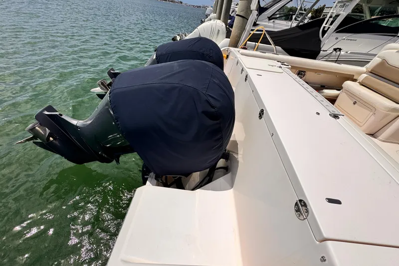 Slide: The Image of 2014 Grady-White Freedom 335 boat with covered outboard motors docked on calm water. - 21