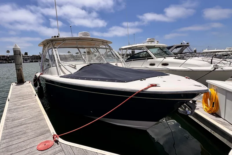Slide: The Image of 2014 Grady-White Freedom 335 boat docked at marina under clear sky. - 22
