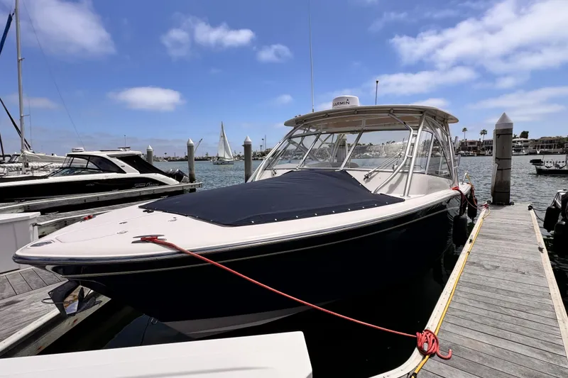Slide: The Image of 2014 Grady-White Freedom 335 boat docked at marina under blue sky. - 23