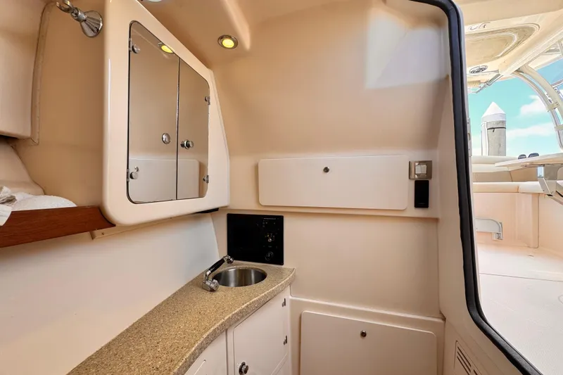 Slide: The Image of Interior of 2014 Grady-White Freedom 335 boat featuring a compact kitchenette with sink. - 29