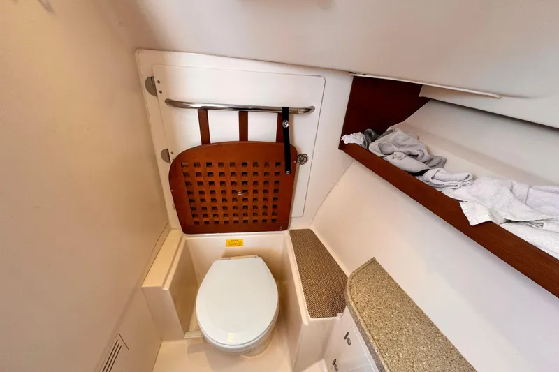 Slide: The Image of 2014 Grady-White Freedom 335 boat bathroom with toilet and wooden accents. - 30