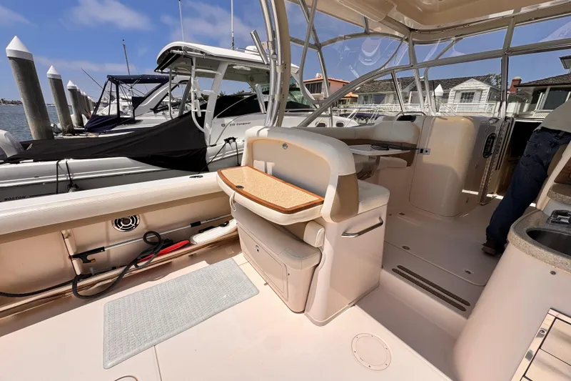 Slide: The Image of 2014 Grady-White Freedom 335 boat interior with seating and docked vessels in background. - 37