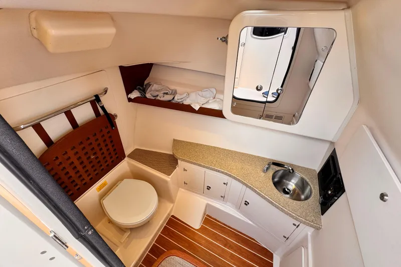 Slide: The Image of 2014 Grady-White Freedom 335 boat bathroom with sink, toilet, and storage cabinets. - 38