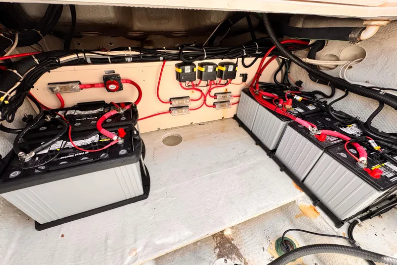 Slide: The Image of Battery compartment of a 2014 Grady-White Freedom 335 boat, featuring multiple batteries and wiring. - 39