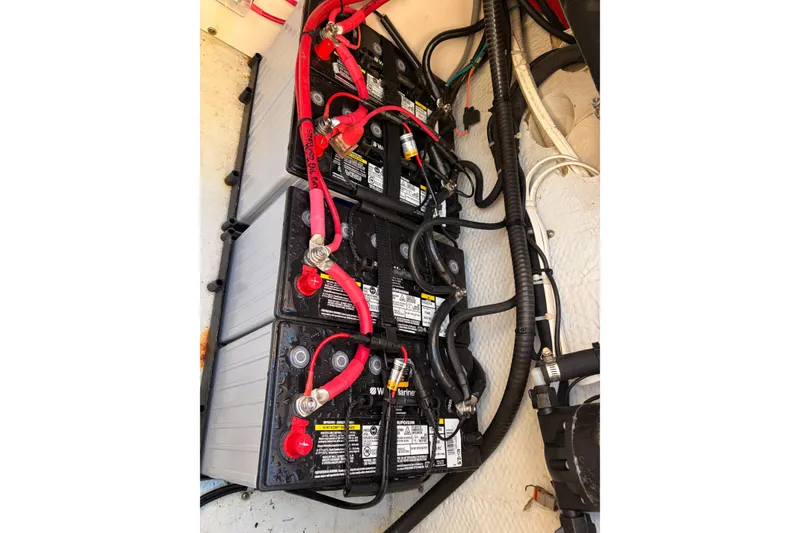 Slide: The Image of Battery setup in a 2014 Grady-White Freedom 335 boat, featuring red and black cables. - 47