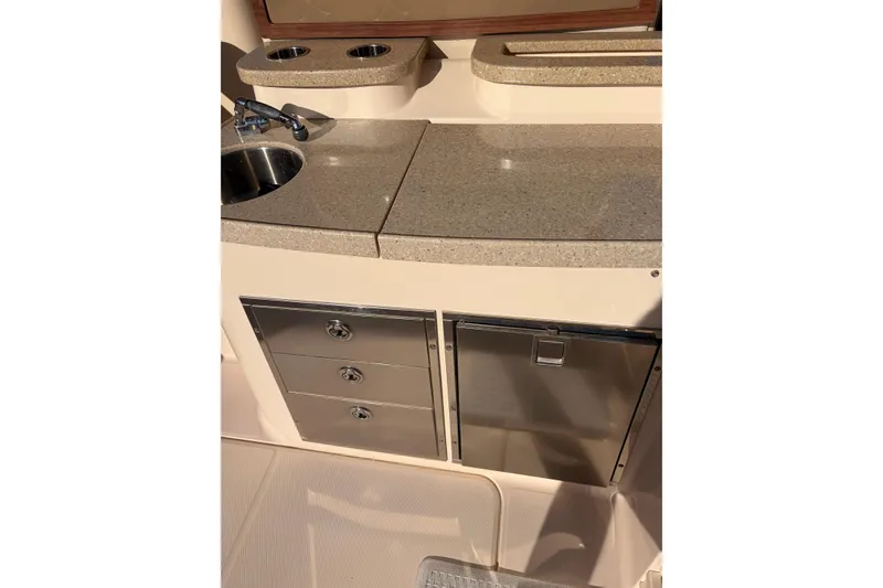 Slide: The Image of 2014 Grady-White Freedom 335 boat kitchenette with sink, storage drawers, and countertop. - 49