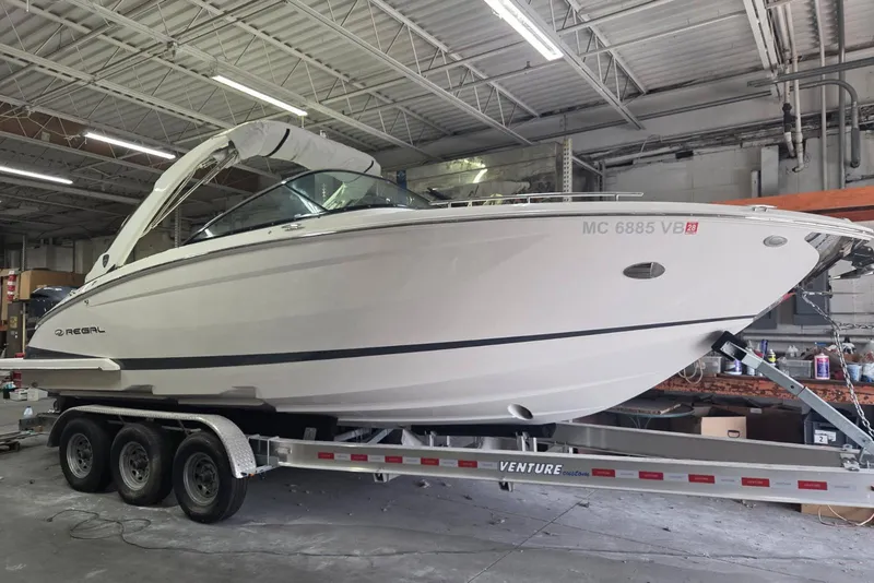 The Image of 2019 Regal 29 OBX boat on trailer in a warehouse setting. - 0