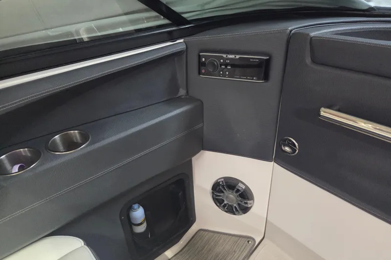 Slide: The Image of Interior of a 2019 Regal 29 OBX boat featuring cup holders and audio controls. - 14