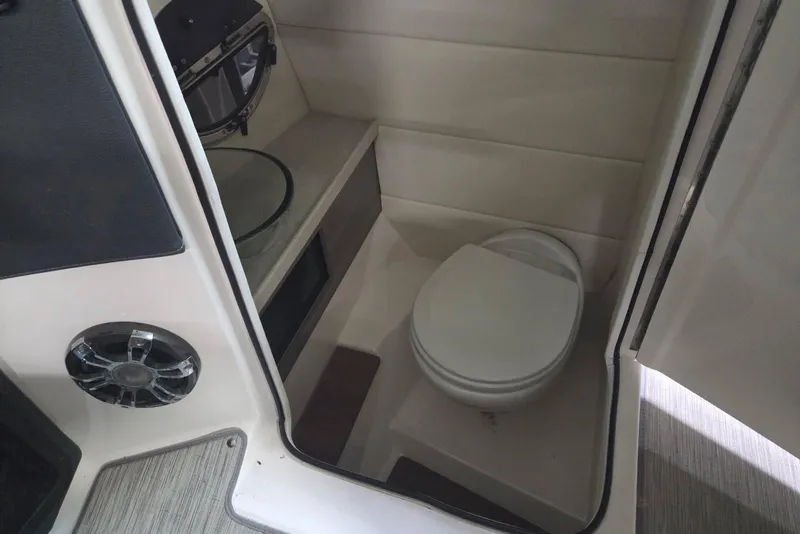 Slide: The Image of Interior of a 2019 Regal 29 OBX boat featuring a compact bathroom with a toilet. - 16
