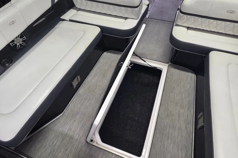 Slide: The Image of 2019 Regal 29 OBX boat interior with open storage compartment and cushioned seating. - 23
