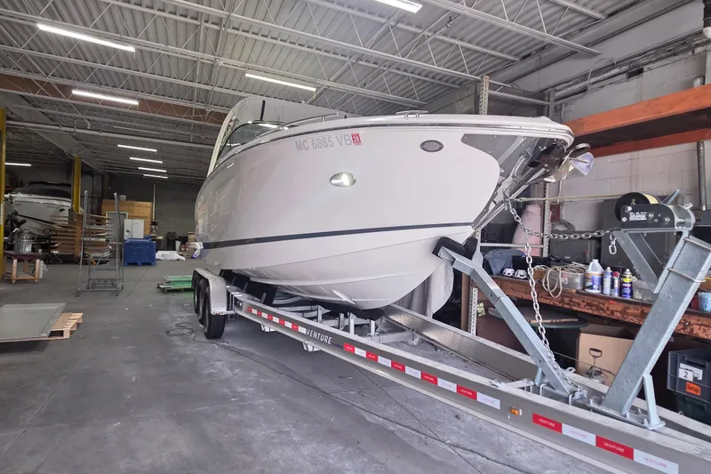 Slide: The Image of 2019 Regal 29 OBX boat on trailer in a warehouse setting. - 25