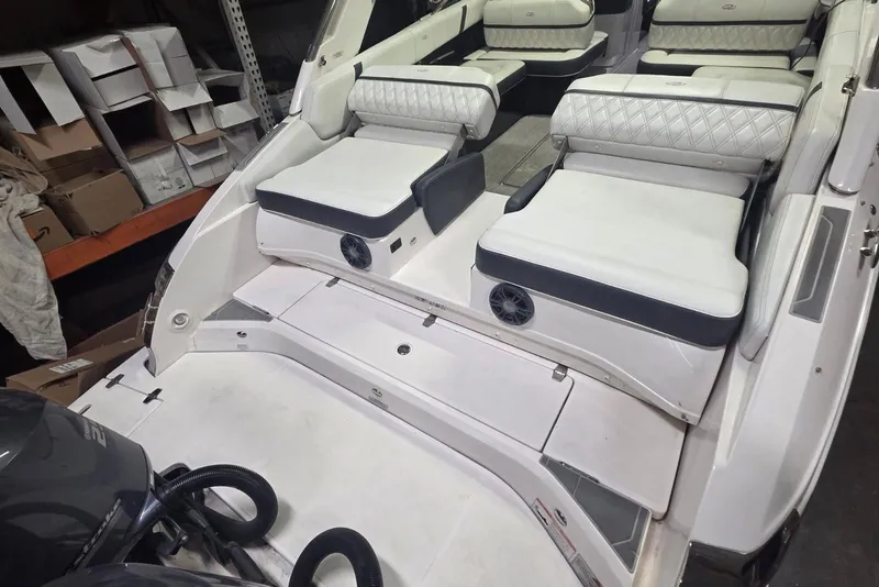 Slide: The Image of 2019 Regal 29 OBX boat interior with white cushioned seating and storage compartments. - 6
