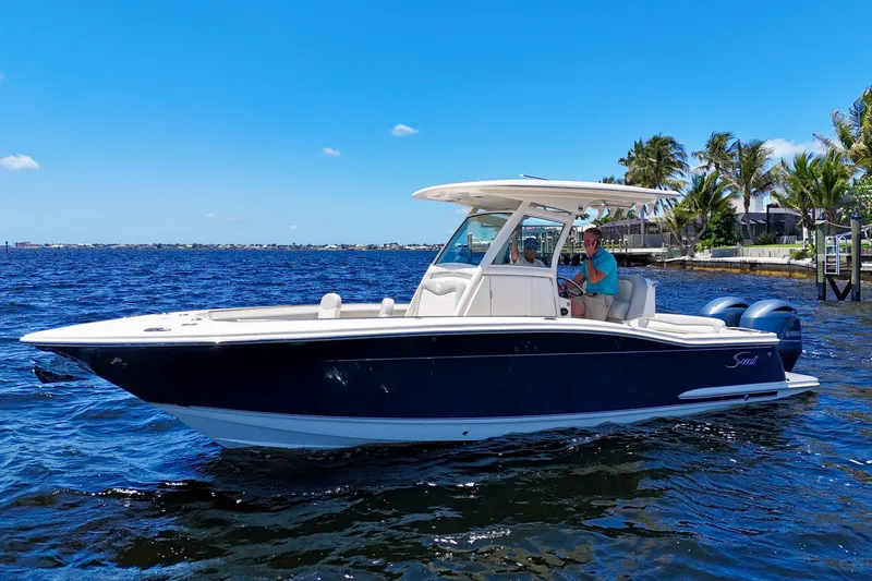 The Image of 2023 Scout 255 LXF boat cruising on a sunny day with clear blue skies. - 0