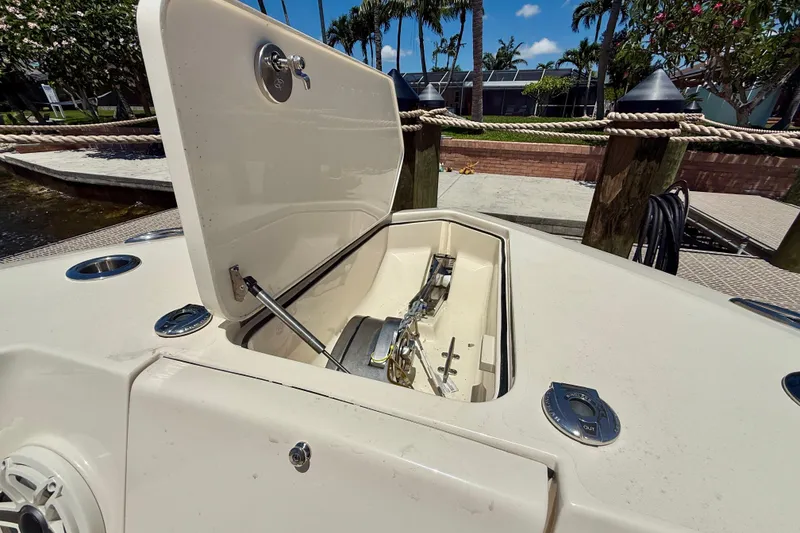 Slide: The Image of 2023 Scout 255 LXF boat anchor compartment open, dockside view. - 13