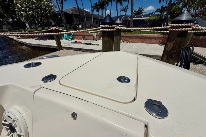 Slide: The Image of 2023 Scout 255 LXF boat deck with dockside view and tropical surroundings. - 14