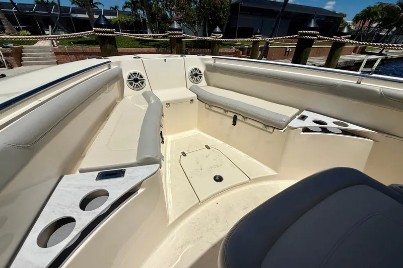 Slide: The Image of 2023 Scout 255 LXF boat interior with seating, cup holders, and speakers. - 15