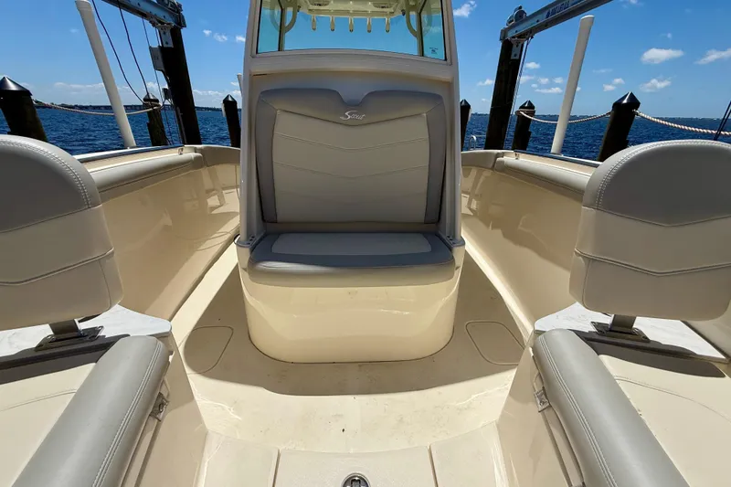Slide: The Image of 2023 Scout 255 LXF boat interior with seating, docked by the ocean. - 17
