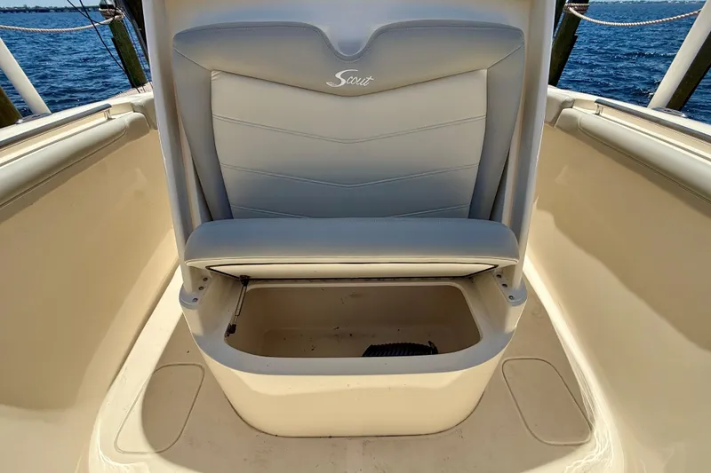 Slide: The Image of 2023 Scout 255 LXF boat seat with storage compartment, open on a sunny day at sea. - 18