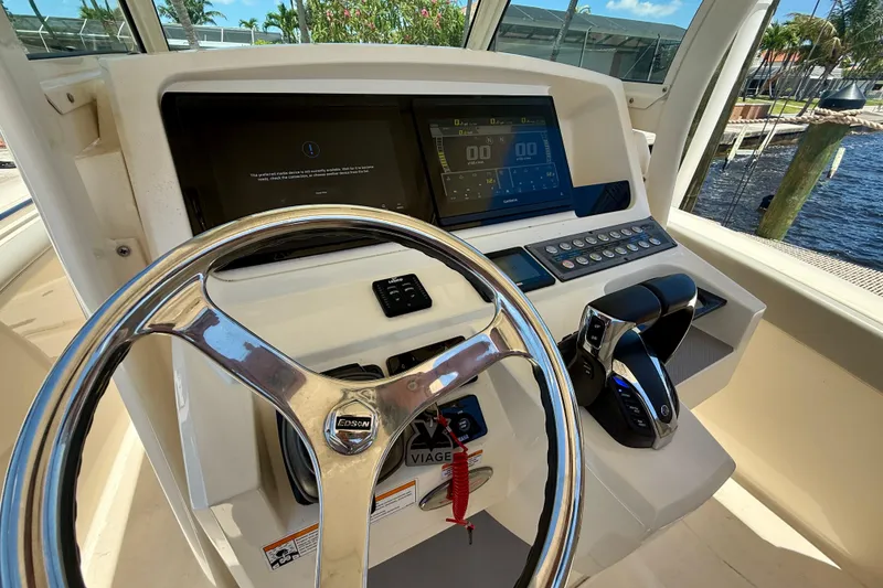 Slide: The Image of Helm of 2023 Scout 255 LXF boat with steering wheel and control panel. - 19