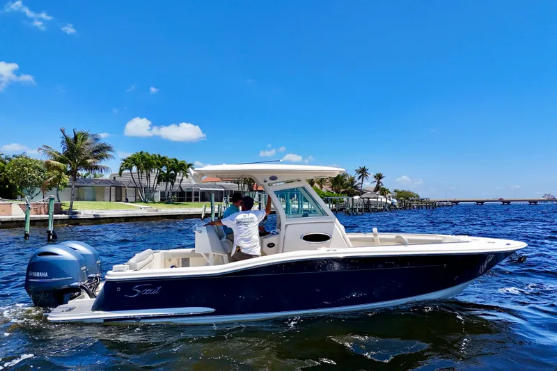 Slide: The Image of 2023 Scout 255 LXF boat cruising on a sunny day with Yamaha engine. - 2