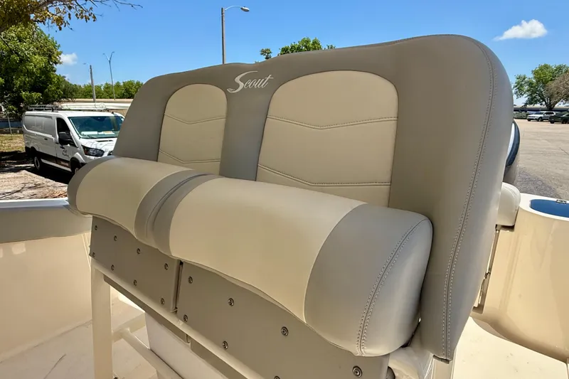Slide: The Image of 2023 Scout 255 LXF boat seat with beige and gray upholstery in outdoor setting. - 21