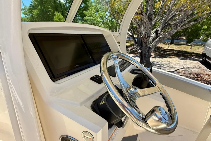 Slide: The Image of 2023 Scout 255 LXF boat helm with steering wheel and dual displays. - 22