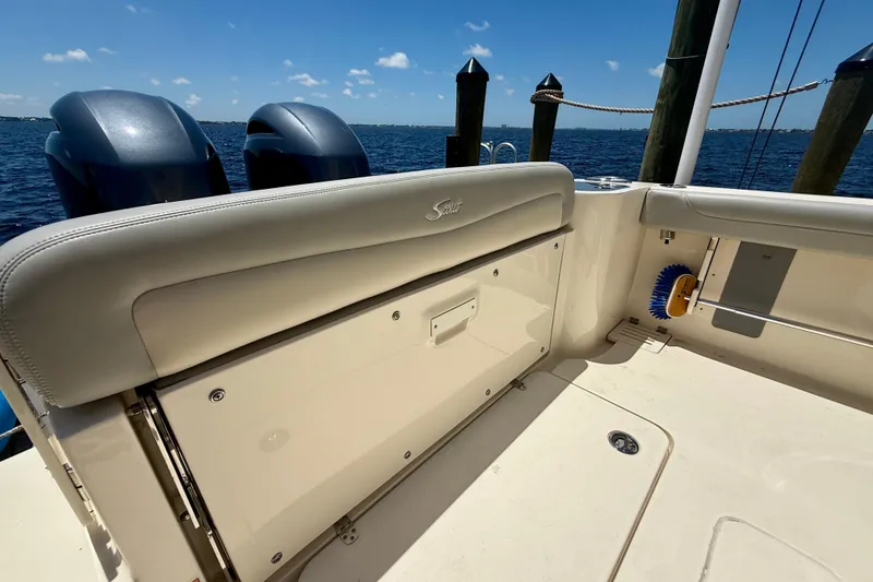 Slide: The Image of 2023 Scout 255 LXF boat interior with dual engines, docked by the water. - 24