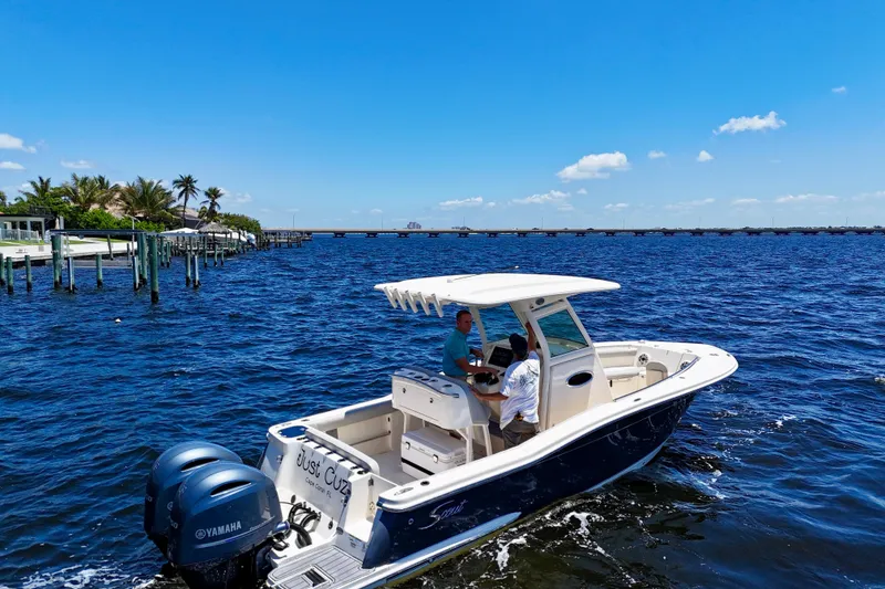 Slide: The Image of 2023 Scout 255 LXF boat cruising on a sunny day with clear blue skies. - 3