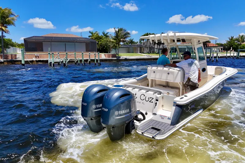 Slide: The Image of 2023 Scout 255 LXF boat cruising on water with twin Yamaha engines. - 5