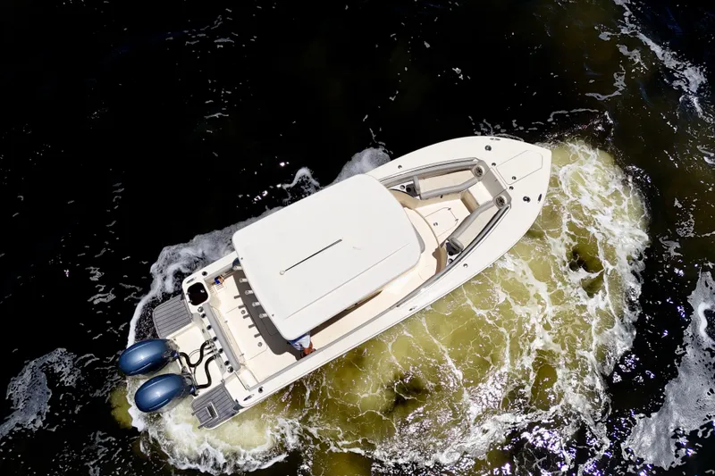 Slide: The Image of 2023 Scout 255 LXF boat cruising on water, aerial view. - 8