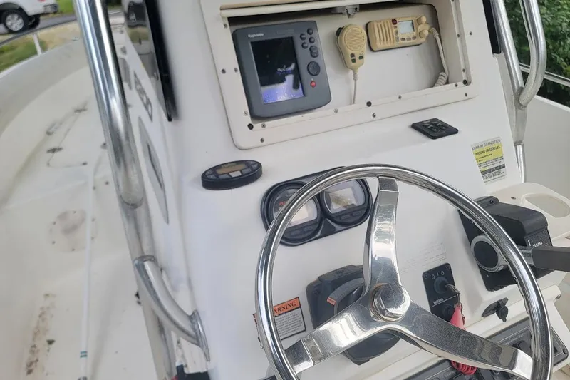 Slide: The Image of 2004 Century 2200 Center Console boat dashboard with steering wheel and navigation equipment. - 13