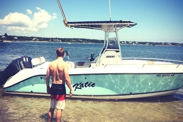 Slide: The Image of Man standing by a 2004 Century 2200 Center Console boat named "Katie" on a sunny beach. - 3