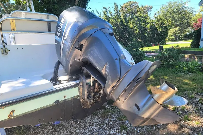 Slide: The Image of 2004 Century 2200 Center Console boat with Yamaha outboard motor in a garden setting. - 9