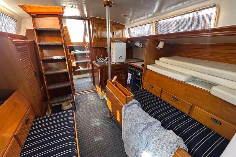 Slide: The Image of Interior of a 1966 CAL Cal 48 sailboat with wooden furnishings and cozy seating. - 10