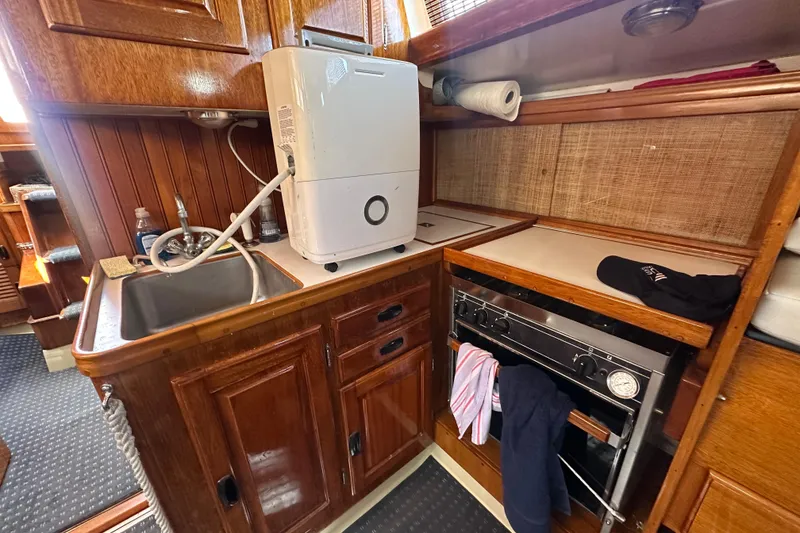 Slide: The Image of Vintage 1966 CAL Cal 48 yacht kitchen with wooden cabinetry and modern appliances. - 11