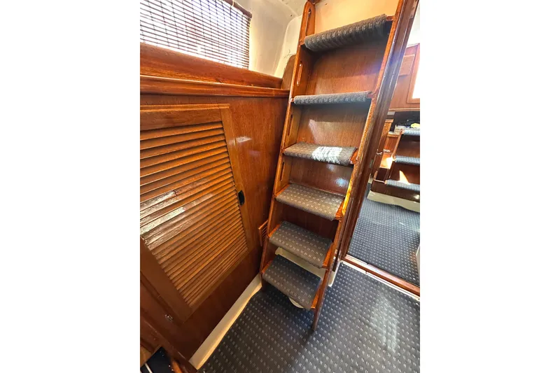 Slide: The Image of Wooden interior stairs of a 1966 CAL Cal 48 yacht with carpeted steps. - 12