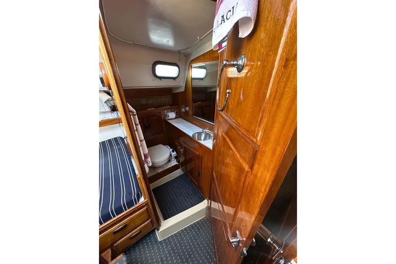 Slide: The Image of Interior of 1966 CAL Cal 48 sailboat with wooden cabinetry and compact bathroom. - 14