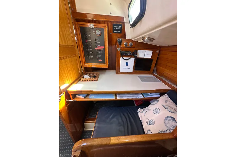 Slide: The Image of Navigation station inside a 1966 CAL Cal 48 sailboat, featuring control panel and seating area. - 17