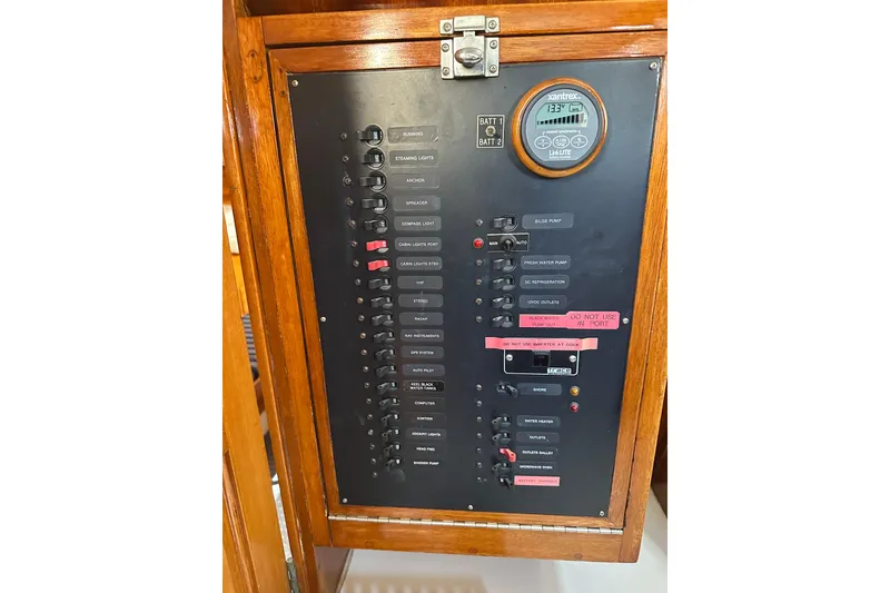 Slide: The Image of Electrical control panel on a 1966 CAL Cal 48 sailboat, featuring switches and a Xantrex monitor. - 19