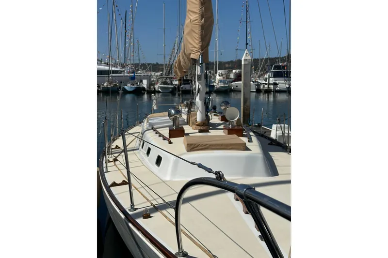 Slide: The Image of 1966 CAL Cal 48 sailboat docked in a marina, showcasing deck and mast. - 2