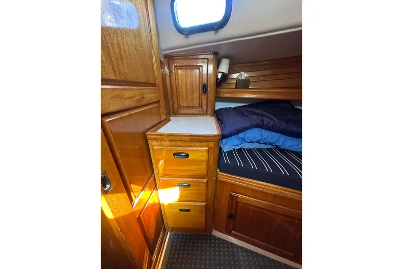 Slide: The Image of Cozy cabin interior of 1966 CAL Cal 48 sailboat with wooden cabinetry and bedding. - 21
