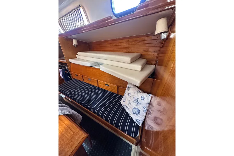 Slide: The Image of Interior of 1966 CAL Cal 48 sailboat with striped seating and wooden cabinetry. - 24