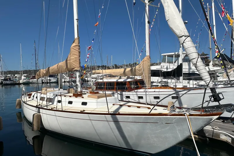 Slide: The Image of Classic 1966 CAL Cal 48 sailboat docked in a marina under clear blue skies. - 29