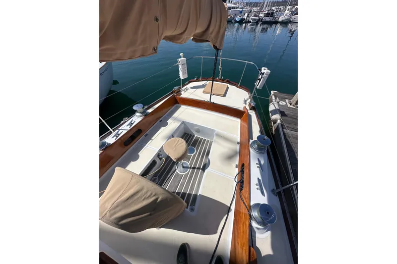 Slide: The Image of 1966 CAL Cal 48 sailboat cockpit with wooden trim, docked in a marina. - 6